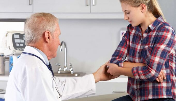 medicul examinează articulațiile mâinilor pentru durere